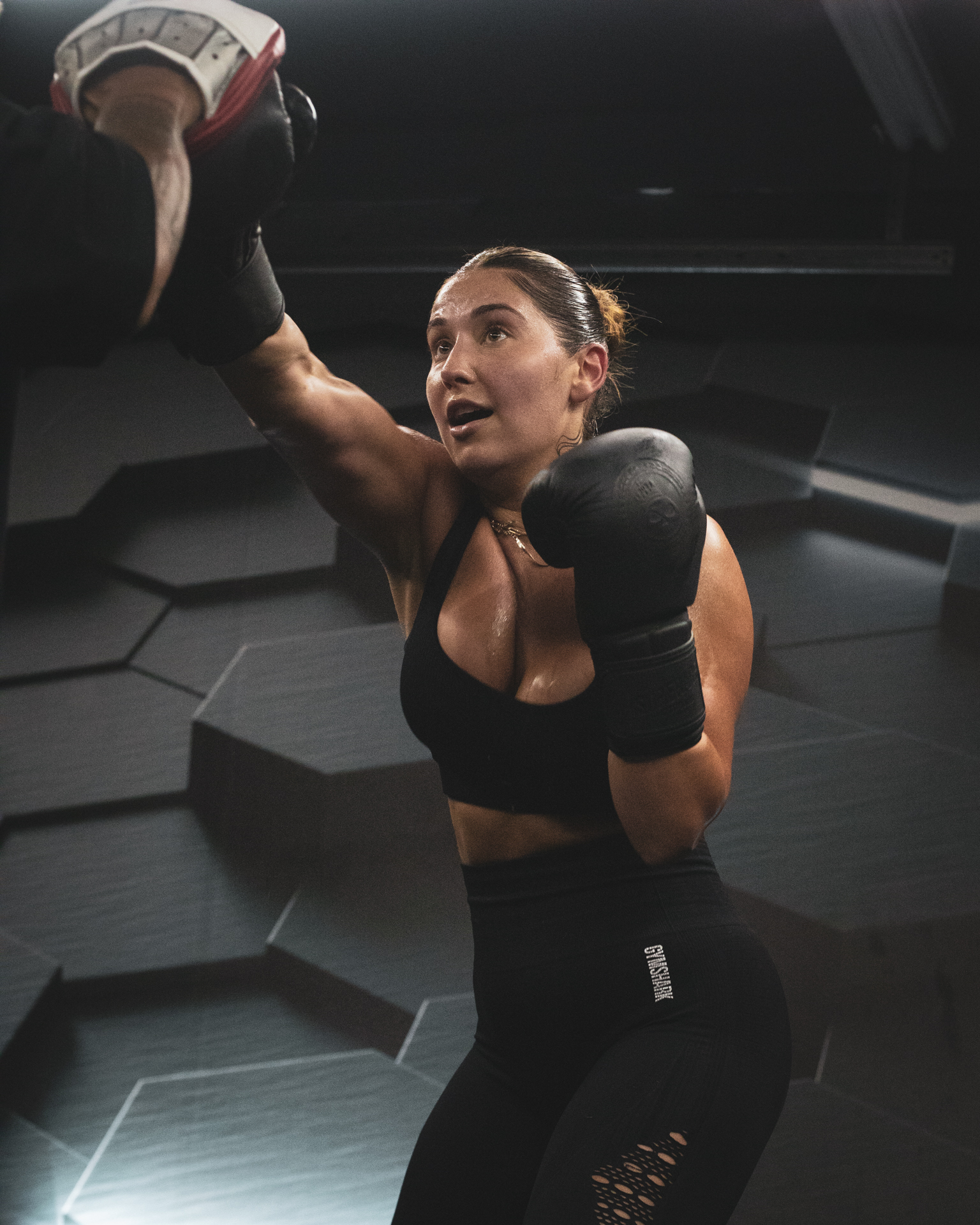 Boxer striking focus mitts during a training session